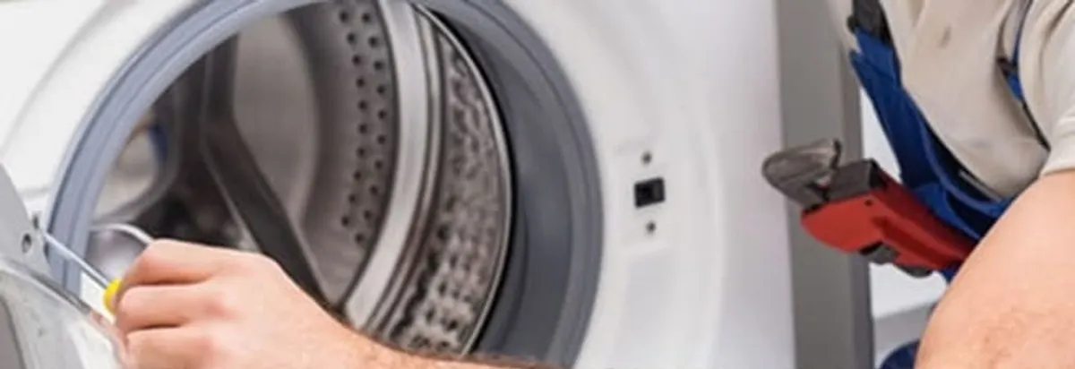 Appliance technician repairing a clothes dryer drum and internal parts in Albany, NY