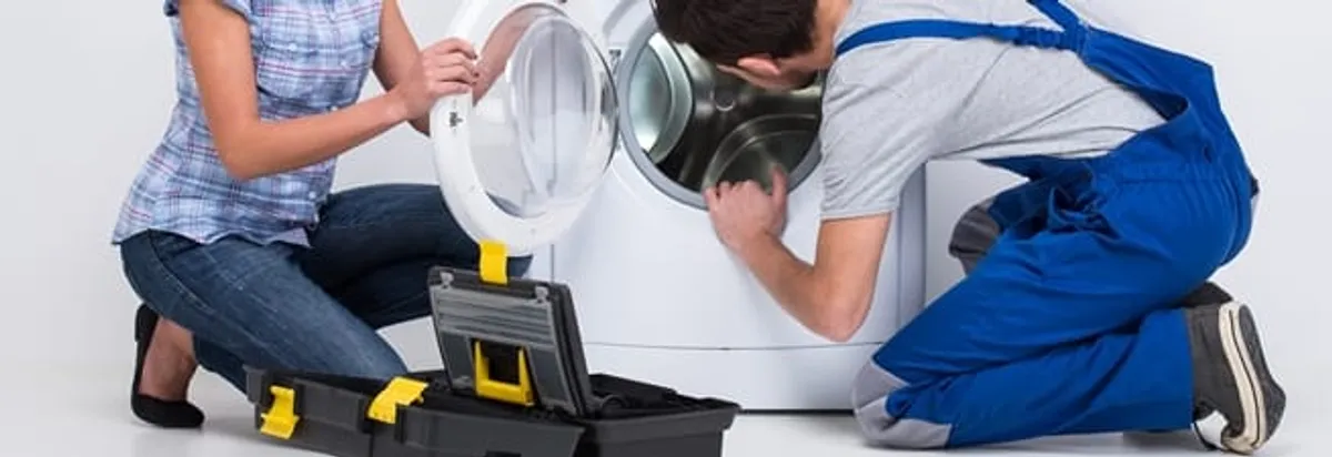 Washer repair technician inspecting a front-load washing machine with tools in Albany, NY