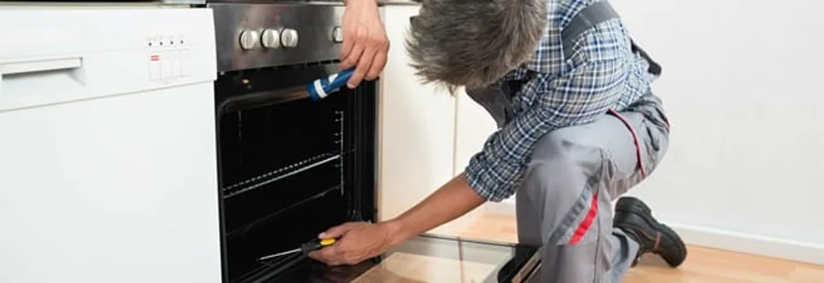 Oven repair technician inspecting and servicing an electric oven in Albany, NY
