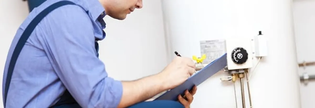 Water heater repair technician inspecting the unit and recording service notes in Albany, NY